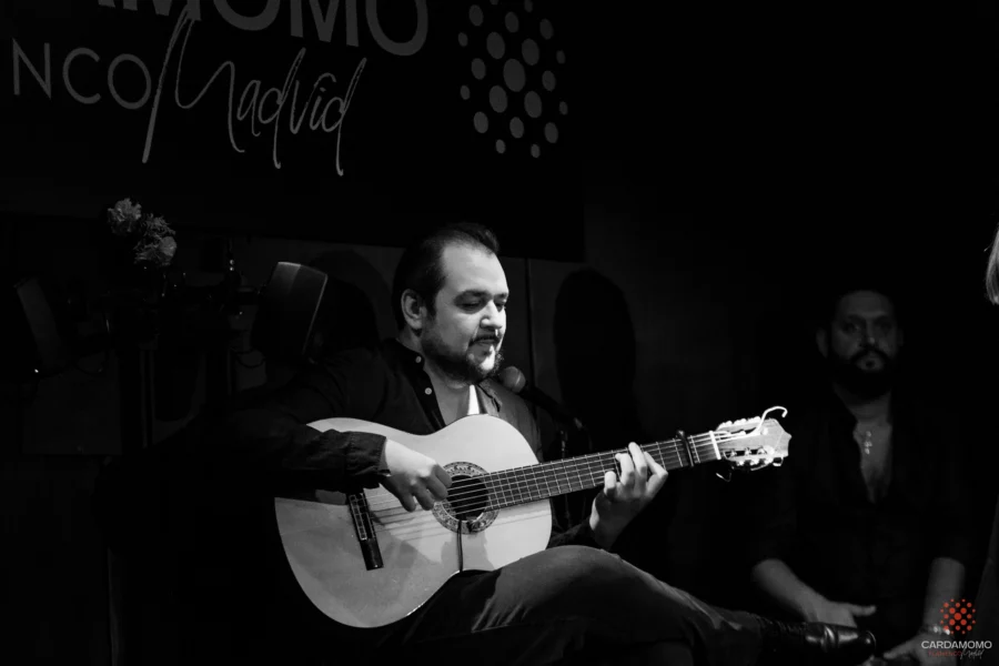 Primer plano dramático del artista de flamenco Kilino Jiménez con expresión intensa y ojos cerrados bajo iluminación de escenario en Cardamomo.