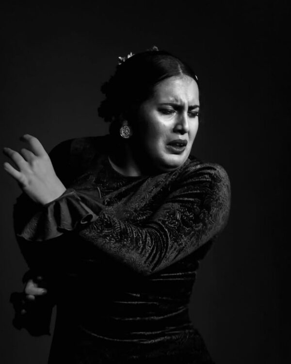 Noemí barrejón con cara de concentración bailando sobre el escenario de un tablao flamenco