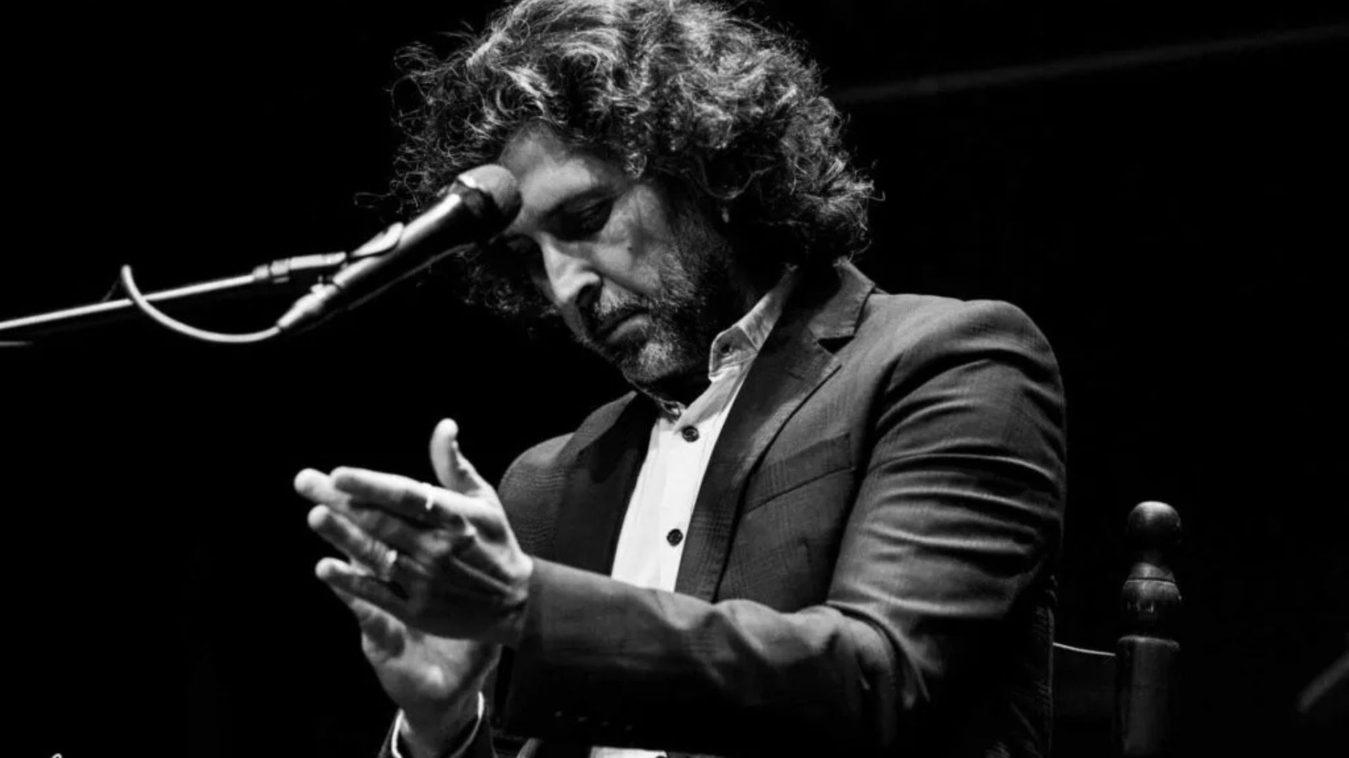El cantaor flamenco Arcángel dando palmas ante el micrófono durante una actuación de cante, una de las voces del cante actual