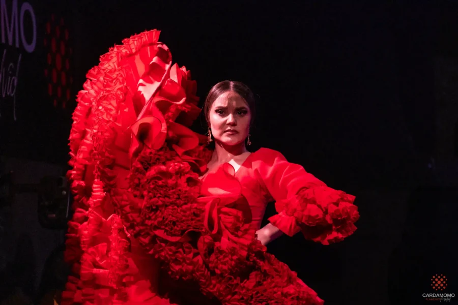 La bailaora Luana Rubín bailando con una bata de cola roja durante un espectáculo de flamenco en Cardamomo, Madrid